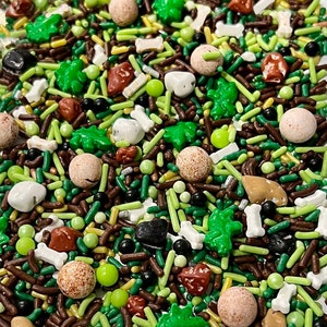 May include: A mix of green, brown, and white sprinkles in the shape of leaves, bones, and small round shapes. The sprinkles are perfect for decorating cakes, cupcakes, and other desserts.