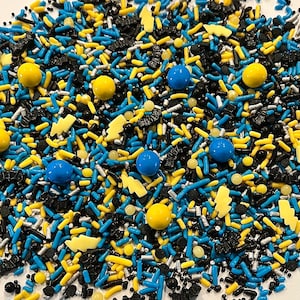 May include: A close-up of a variety of colorful sprinkles, including blue, yellow, and black. The sprinkles are arranged in a random pattern and are perfect for decorating cakes, cupcakes, and other desserts.