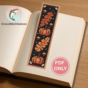 May include: A handmade bookmark featuring a fall theme with pumpkins and leaves in shades of orange and brown on a black background. The bookmark is placed in an open book. The text "PDF ONLY" is visible.