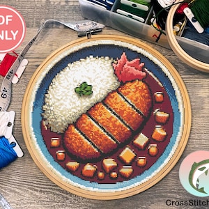 Könnte beinhalten: Ein Kreuzstichmuster eines japanischen Gerichts mit Reis, paniertem Schweinefleisch und brauner Sauce. Das Muster befindet sich in einem hölzernen Stickrahmen auf einem Holztisch. Das Muster stammt von CrossStitchSalmon.