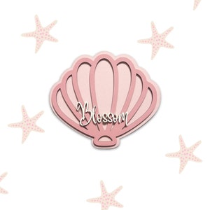 Puede incluir: Concha rosa con un recorte blanco de la palabra "Blossom" en su interior. La concha está rodeada de estrellas de mar rosas.