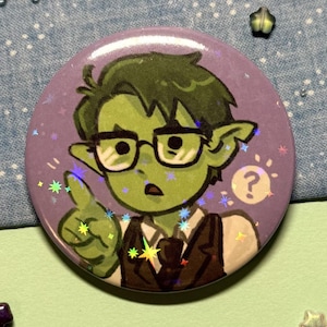 May include: A round button with a cartoon illustration of a green-skinned character wearing glasses and a suit. The character is pointing with one finger and has a question mark next to them. The button has a purple background with glitter.