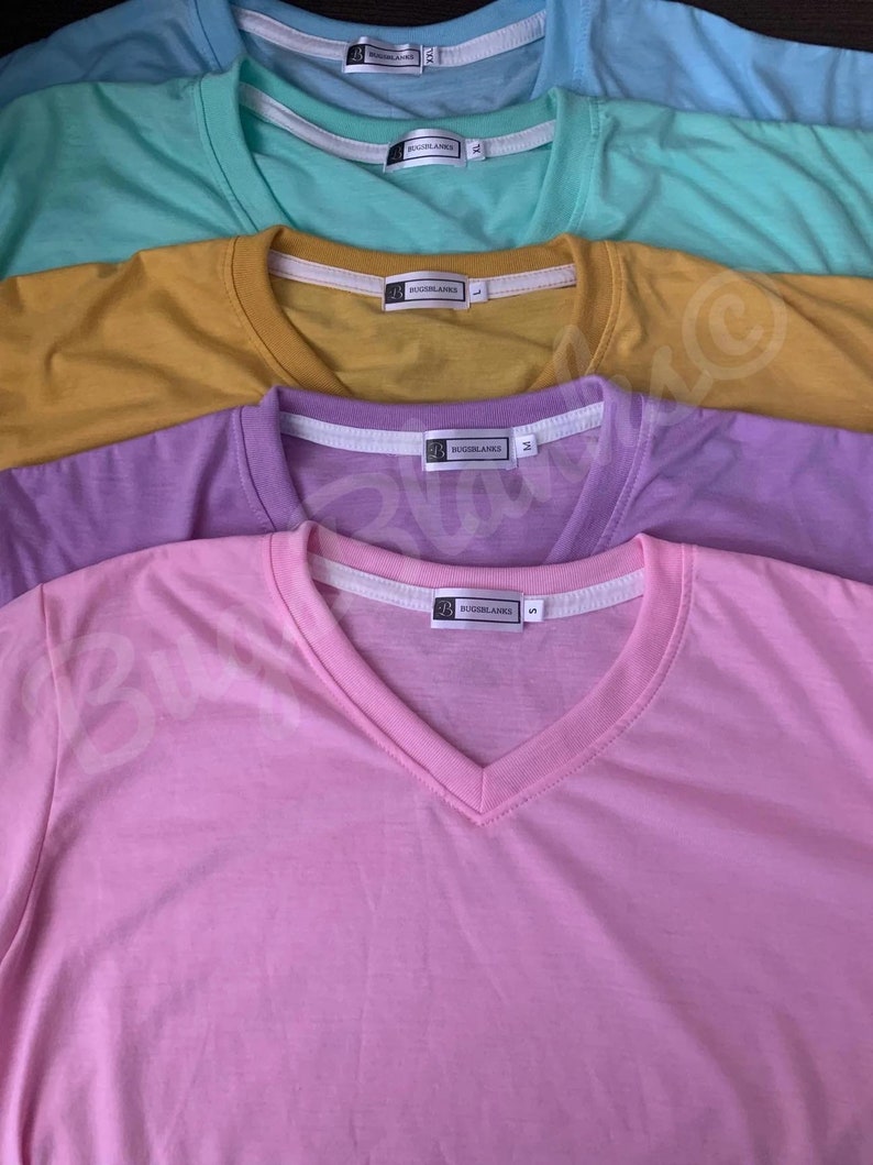 May include: A collection of V-neck t-shirts in various pastel colors: light blue, mint green, mustard yellow, lavender, and pink. Each shirt has a white tag with the brand name. The shirts are neatly arranged, showcasing their different hues.