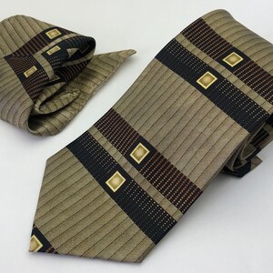 May include: A brown and beige striped tie with black and brown geometric patterns and gold accents. A matching pocket square is included.