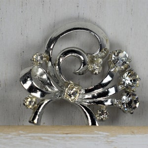 Vintage 1960&#39;s silver tone metal and rhinestone ribbon brooch