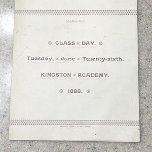 May include: A white ceramic mug with a black handle and the text "But First, Coffee" in a handwritten style. The mug is on a white surface. The mug is likely for hot beverages.