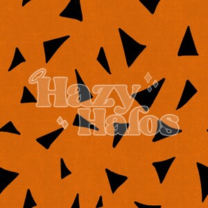 May include: Orange background with a repeating pattern of black triangles. The text "Hazy Halos" is in the center of the image.