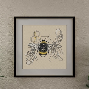 May include: A black framed print with a beige background featuring a black and yellow bee surrounded by geometric shapes. The bee is in the center of the print and is surrounded by a honeycomb pattern.