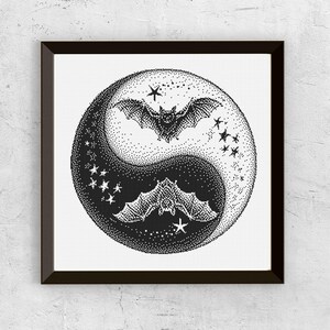 Può includere: Opera d'arte incorniciata in bianco e nero con un design Yin e Yang con pipistrelli e stelle. I pipistrelli sono in volo e le stelle sono sparse intorno a loro. L'opera è un'illustrazione basata su punti.