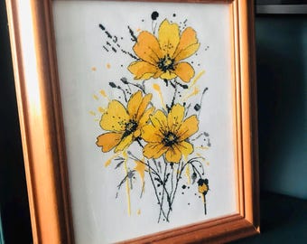 May include: A framed cross-stitch embroidery featuring three yellow flowers with black stems and leaves on a white background.