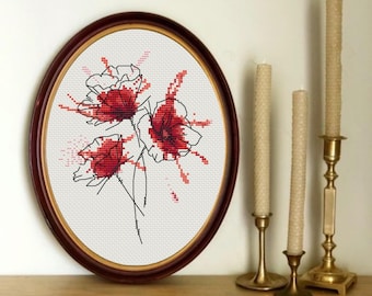 May include: A framed cross-stitch embroidery featuring three red poppies with black outlines on a white background.