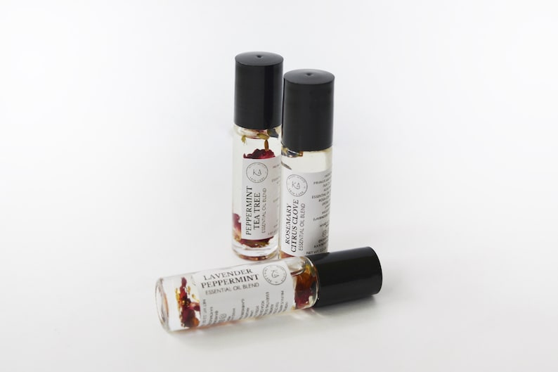 Pode incluir: Tr&ecirc;s frascos de &oacute;leo essencial roll-on com tampas pretas. Um frasco &eacute; rotulado "Lavanda Hortel&atilde;-pimenta", outro "Hortel&atilde;-pimenta Tea Tree", e o terceiro "Alecrim C&iacute;trico Cravo".