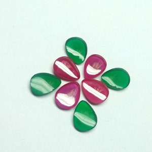 Pode incluir: Oito pedras preciosas em forma de lágrima dispostas em um padrão circular. Quatro são verdes e quatro são rosas.