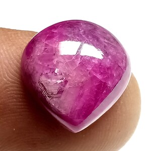 Op de afbeelding: Een roze edelsteen cabochon met een traanvorm. De edelsteen heeft een getextureerd oppervlak en een glanzende afwerking.