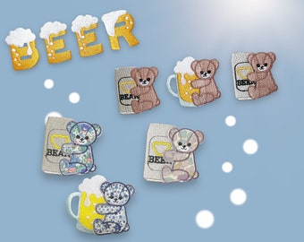 May include: A set of embroidered iron-on patches featuring a bear holding a beer mug. The patches are in various colors, including brown, blue, and yellow. The text "BEER" is embroidered in yellow on a white background.