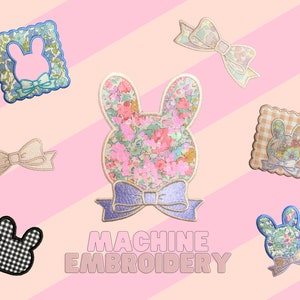 May include: A set of eight machine embroidery patches featuring floral and checkered patterns. The patches include a bunny, a bow, and a frame. The text "MACHINE EMBROIDERY" is displayed below the patches.