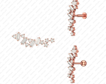 May include: A pair of rose gold ear cartilage earrings with a curved row of small, clear cubic zirconia stones. The earrings are designed to be worn in the upper ear cartilage.