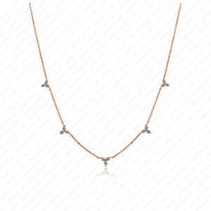 Puede incluir: Un delicado collar de oro con cinco pequeños acentos de diamantes de tres puntas. El collar está hecho de una cadena fina y tiene un diseño simple y elegante.