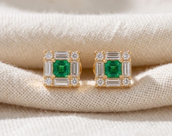 May include: A pair of square gold stud earrings, each featuring a central square-cut green gemstone surrounded by a halo of four baguette-cut clear stones and four round brilliant-cut clear stones set at the corners of the square frame.