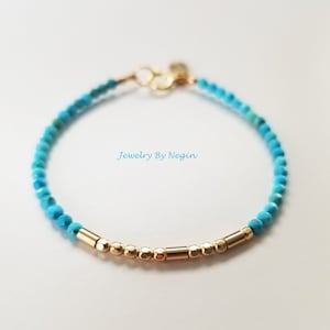 Peut inclure: Un bracelet en perles turquoise et or. Le bracelet est composé de petites perles turquoise et de perles et de barres dorées.