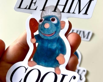 Op de afbeelding: Witte sticker met de tekst "Let Him Cook" in zwarte letters. Een cartoonrat met een koksmuts en een houten lepel in zijn hand bevindt zich in het midden van de sticker.