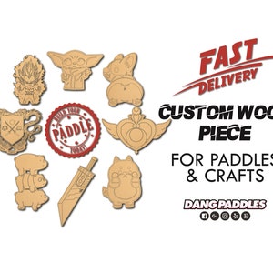 May include: A collection of custom wood pieces featuring various cartoon characters, including a baby Yoda, a cat, and a sword. The text "Build Your Paddle Today" is on a red circle. The text "Fast Delivery" is on a red banner. The text "Custom Wood Piece" is in black text. The text "For Paddles & Crafts" is in black text. The text "Dang Paddles" is in black text with social media icons.
