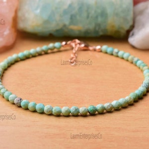 Peut inclure: Un bracelet délicat en perles turquoise avec un fermoir en or rose. Les petites perles rondes sont un mélange de turquoise clair et foncé, enfilées pour former un bijou simple et élégant. Le bracelet mesure environ 18 cm de long.