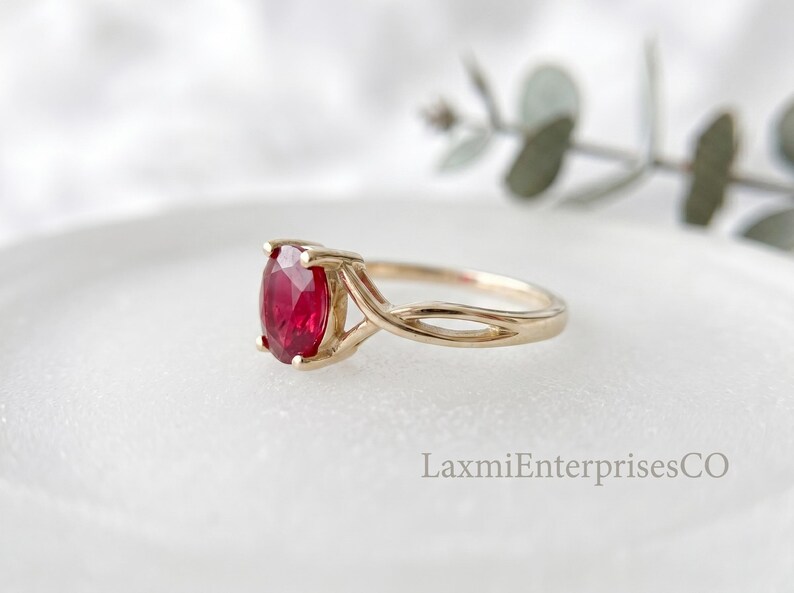 Side view of handcrafted sterling silver ruby ring featuring a faceted oval ruby gemstone in a secure prong setting.