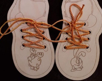 May include: Two white canvas shoes with orange and yellow laces. One shoe has a cartoon moose and the other has a cartoon bunny.
