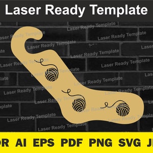 May include: Laser cut template for a yarn holder, shaped like a sock with three balls of yarn. The template is beige and the background is a black brick wall. The text "Laser Ready Template" is repeated throughout the image.