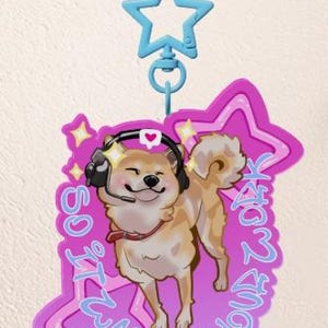 May include: A light brown Shiba Inu dog wearing a headset and a red collar, smiling. The dog is on a pink star-shaped background with the text "SO IT WAS ALL YOUR FAULT" in blue. A blue star-shaped clip is attached.