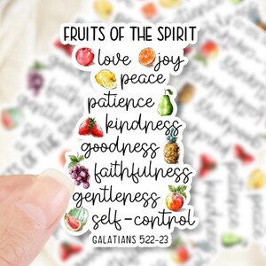 May include: A die-cut sticker featuring the text FRUITS OF THE SPIRIT followed by a list of virtues including love, joy, peace, patience, kindness, goodness, faithfulness, gentleness, and self-control, each paired with a small watercolor fruit illustration.