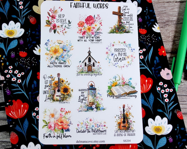 May include: A sticker sheet with the words "Faithful Words" and various floral and religious designs. The stickers include phrases like "God is Love," "Protected by His Grace," and "Let us worship together." The sheet is on a floral patterned background.