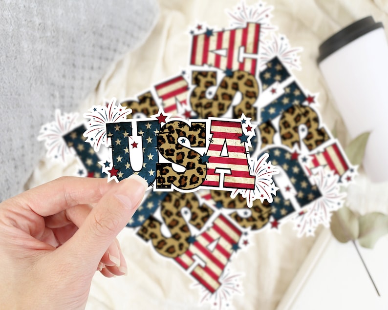 May include: A set of six "USA" stickers featuring a red, white, and blue American flag design with leopard print accents and firework details.