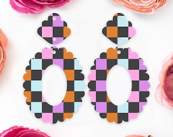 May include: A pair of colorful checkerboard earrings. The earrings feature a scalloped oval shape with a smaller, matching top piece. The checkerboard pattern includes black, orange, pink, purple, and light blue squares. The earrings are designed to be lightweight and eye-catching.