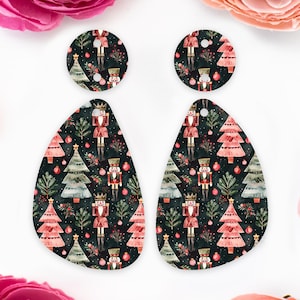 May include: A pair of Christmas earrings with a dark background. The earrings feature a pattern of nutcrackers, Christmas trees, and ornaments. The earrings are in a teardrop and circular shape.