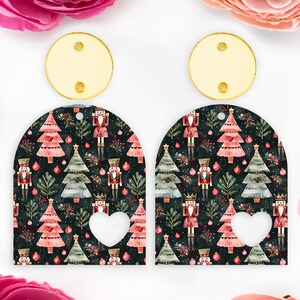 May include: A pair of Christmas earrings. Each earring has a gold-coloured circular top with two holes. The lower section is an arch shape with a dark background and a pattern of Christmas trees, nutcrackers, and baubles.