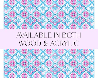 May include: A rectangular decorative item with a repeating floral pattern in shades of blue, pink, and white. The text "AVAILABLE IN BOTH WOOD & ACRYLIC" is displayed across the center of the item.