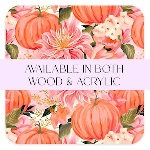 May include: A seamless pattern featuring pink flowers, green leaves, and orange pumpkins. The text "AVAILABLE IN BOTH WOOD & ACRYLIC" is displayed on a purple banner.