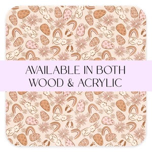 May include: A seamless pattern featuring bunnies, eggs, rainbows, and flowers in shades of brown, pink, and cream. The text "AVAILABLE IN BOTH WOOD & ACRYLIC" is displayed on a purple banner.