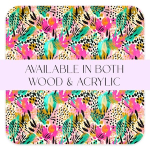 May include: Abstract pattern in pink, teal, gold, and black on a white background. The design features floral and spotted elements. Text on a light purple banner reads "AVAILABLE IN BOTH WOOD & ACRYLIC".