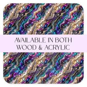May include: Two rectangular items with a swirling galaxy design in shades of blue, purple, gold, and black. The text "AVAILABLE IN BOTH WOOD & ACRYLIC" is displayed in white on a pink background between the items. The design features a cosmic, flowing pattern.