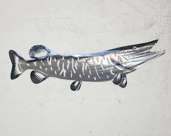 Puede incluir: Una escultura de pared de metal de un lucio con un diseño detallado. El pez es de color plateado y tiene un acabado texturizado.