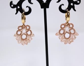 May include: A pair of gold hoop earrings with delicate beaded fringe. The fringe is made of small, white beads and gold wire, creating a delicate and feminine look.