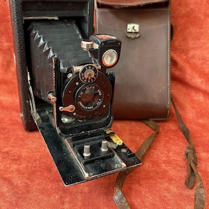 Fotocamera del 1914 circa. La carabina. Aldis UNO Anastigmat F77. Fotocamera britannica a soffietto pieghevole. Fotocamera con custodia in pelle pesante. Otturatore Lukos III.