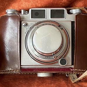 Fotocamera Balda Super Baldina. Fotocamera con obiettivo pop-out del 1954. Otturatore Pronto. Balda Werk tedesca. Obiettivo Baldanar 1:3.5 / 50. Custodia in pelle. 35 mm