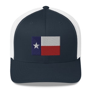 May include: A navy blue and white trucker hat with an embroidered Texas flag on the front.