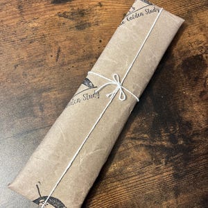 May include: A brown paper package tied with white string. The package is labeled "The Golden Study".