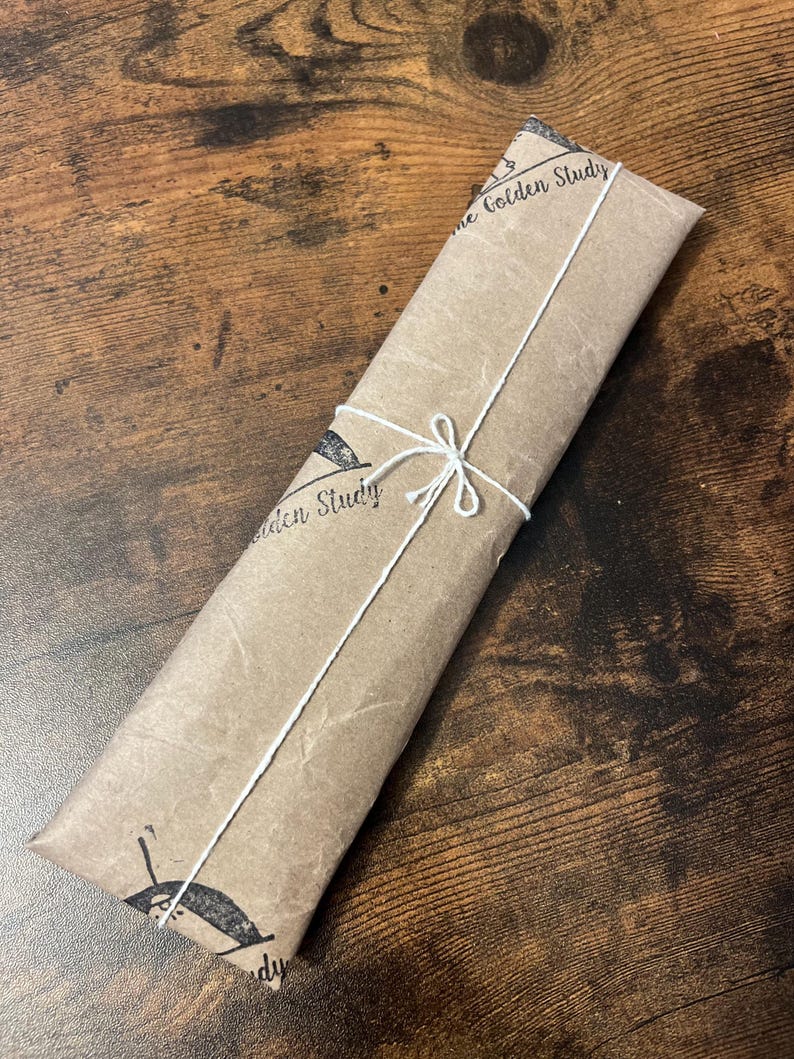 May include: A brown paper package tied with white string. The package is labeled "The Golden Study".