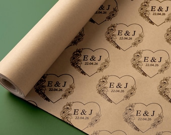 Puede incluir: Rollo de papel kraft marrón con un patrón repetido de diseños en forma de corazón. Cada corazón contiene las iniciales "E & J" y la fecha "22.04.26", rodeado de elementos florales. Ideal para envolver regalos.